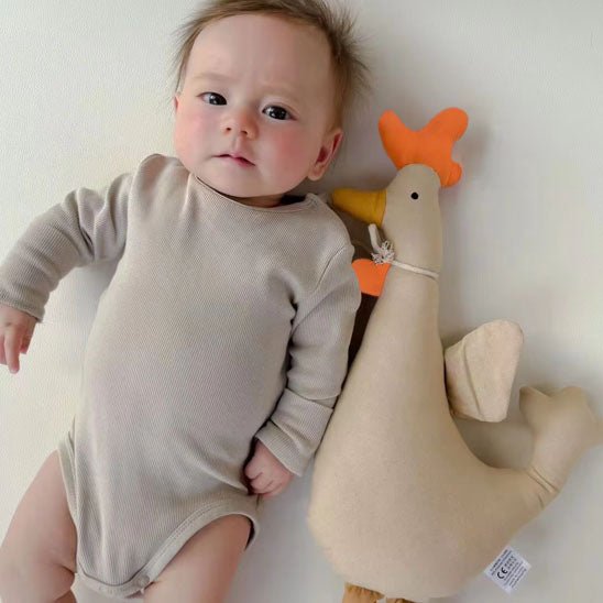 Doudou coq allongé à cÎté de bébé